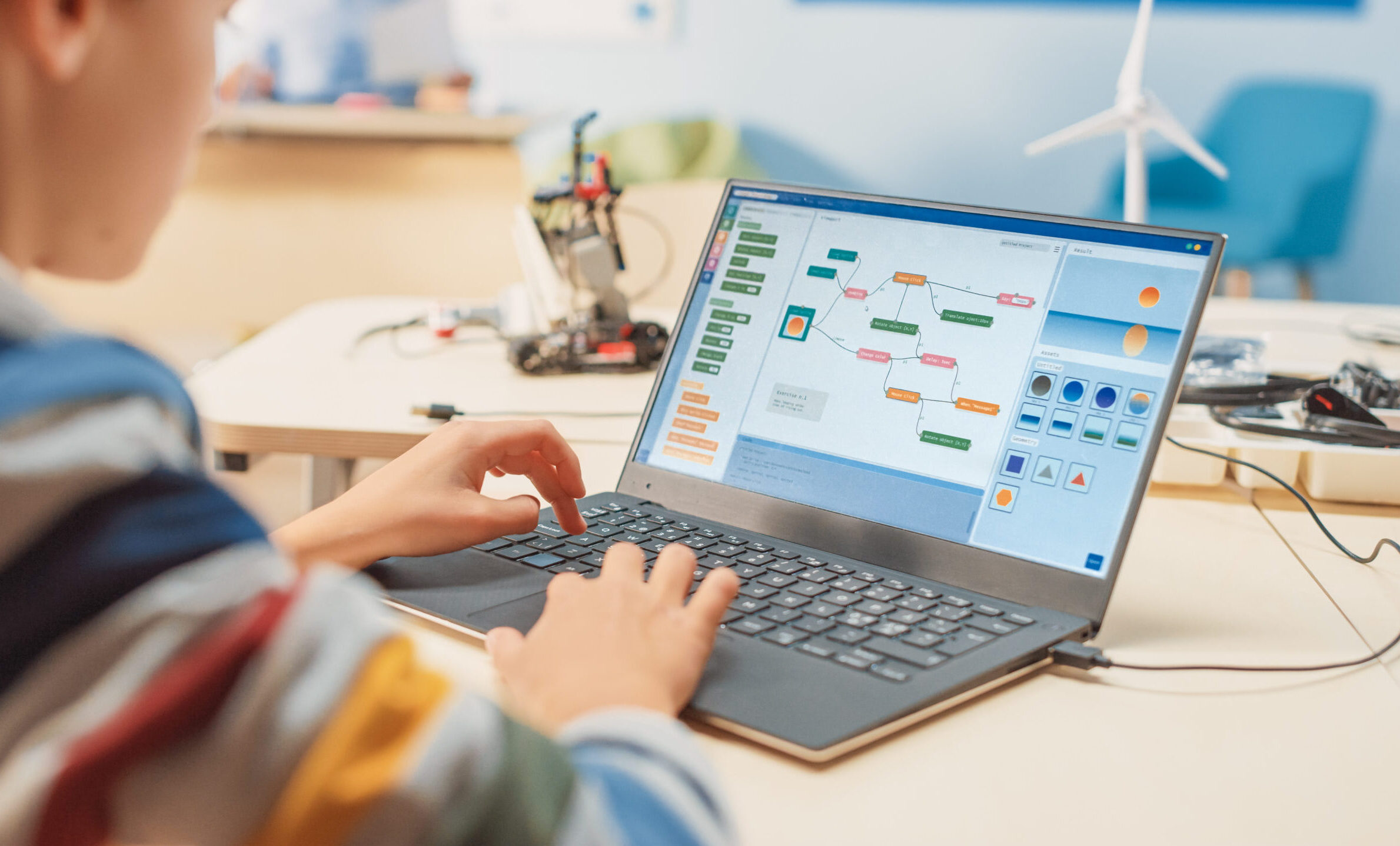 Smart Schoolboy Uses Laptop to Program Software for Robotics Eng